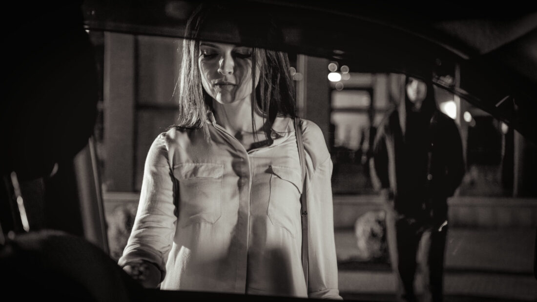 Woman walking toward her car with a suspicious man approaching from behind, illustrating self defense awareness