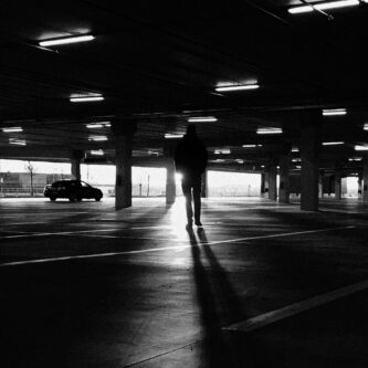 Man walking toward her car in dangerous parking lot, illustrating self defense awareness